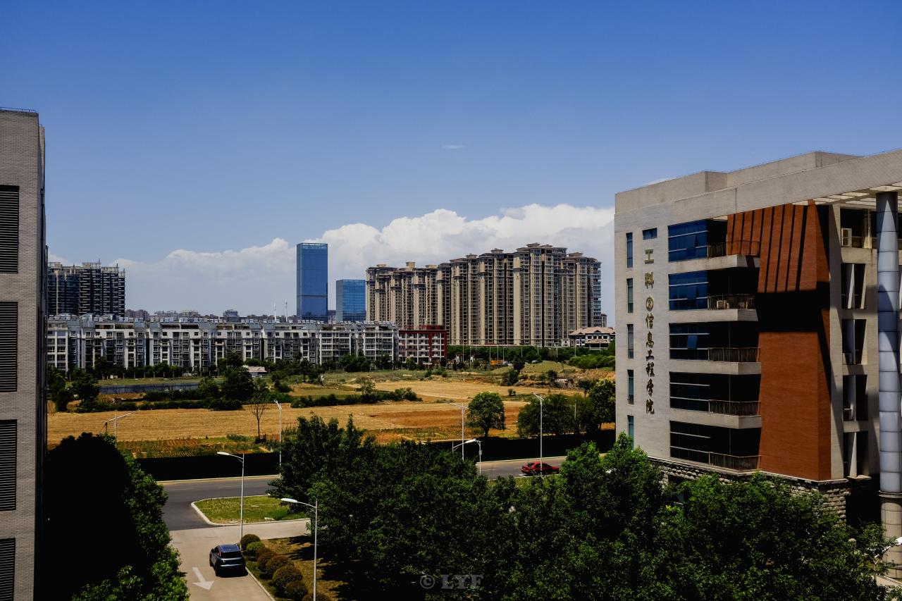 white and blue concrete building near green trees during daytime