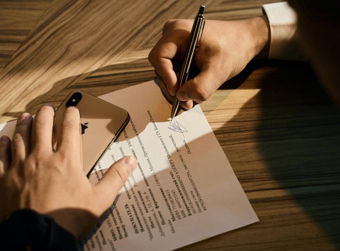 person writing on white paper