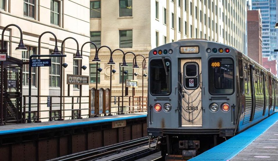 gray train on rail road near building during daytime